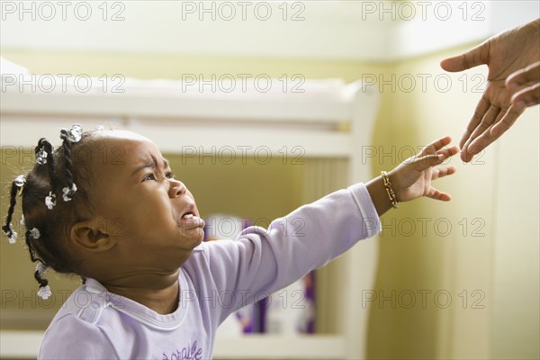 African girl crying and reaching upward