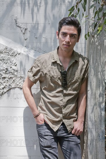 Mixed race teenage boy leaning against wall