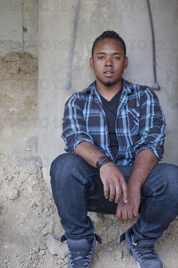 Confident Black teenage boy crouching