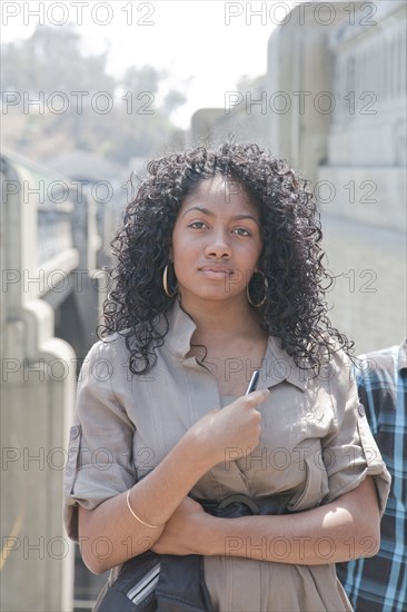 Serious Black teenage girl holding cell phone