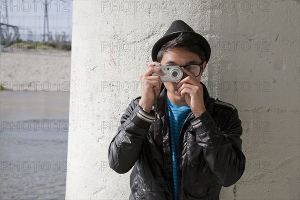 Mixed race teenage boy taking photograph with digital camera