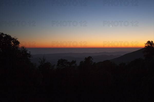 Sunset sky over silhouette of remote mountains