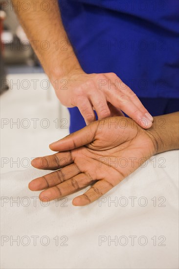 Close up of doctor checking pulse of patient