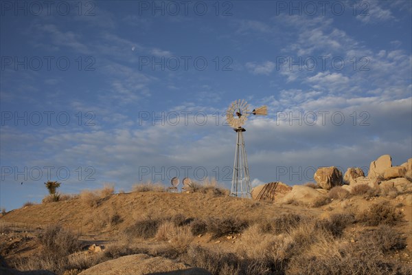 Windmill over rock formations in desert field