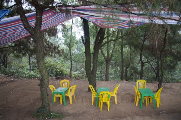 Tables and chairs under canopy in remote forest