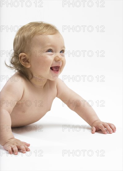 Mixed race baby girl crawling on floor