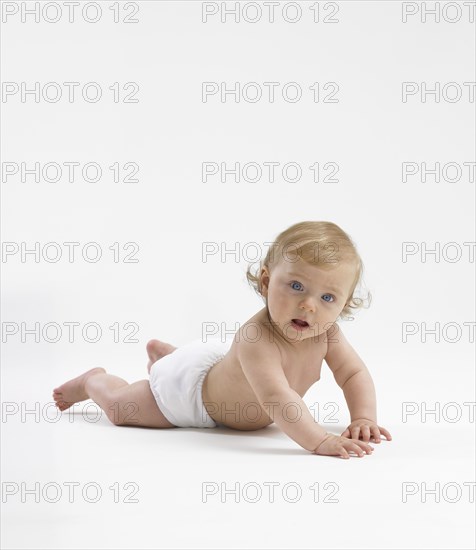 Mixed race baby girl crawling on floor