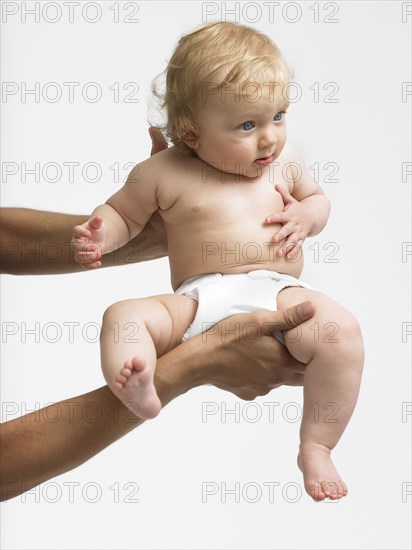 Arms of mixed race father holding baby girl