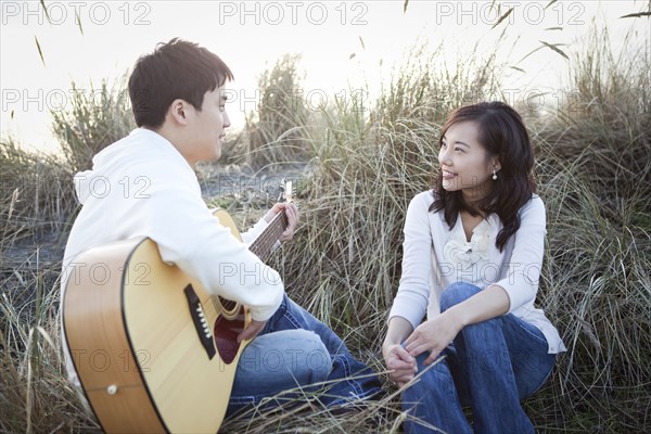 Korean man playing guitar for girlfriend