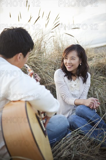 Korean man playing guitar for girlfriend