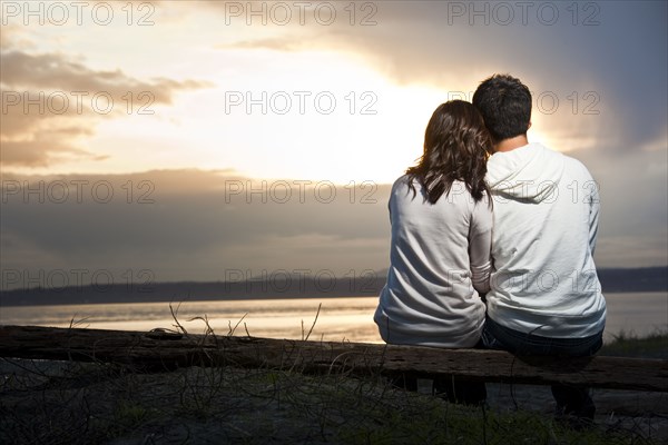 Korean couple enjoying sunset at beach