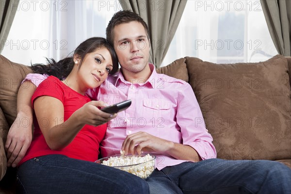 Couple sitting on sofa and watching television