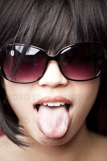 Chinese woman wearing sunglasses and tongue out