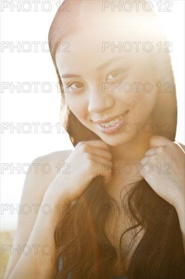 Smiling Chinese woman holding her hair