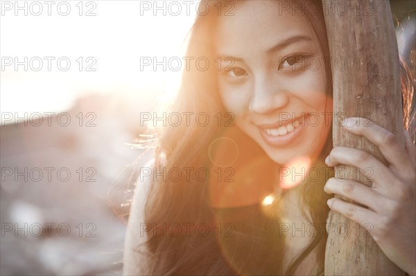 Chinese woman leaning on tree trunk