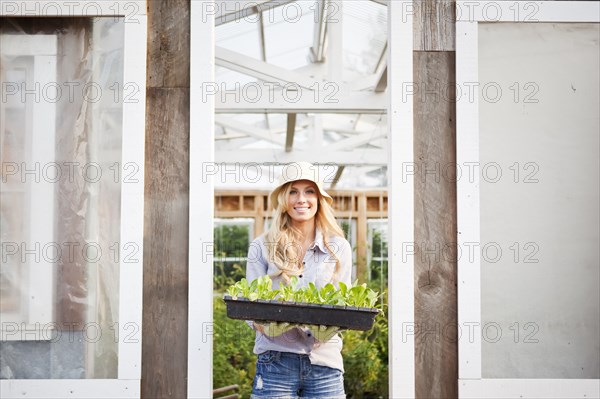Caucasian woman holding tray of plants