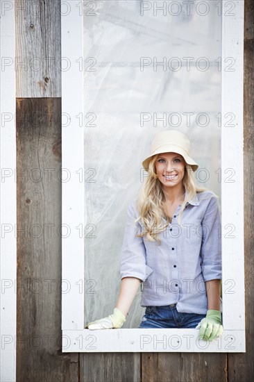 Caucasian woman wearing gloves standing in window