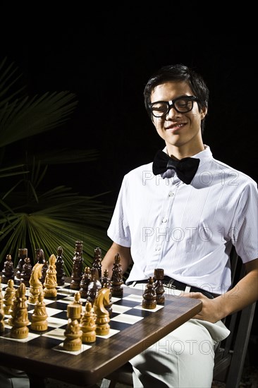 Mixed race geek playing chess