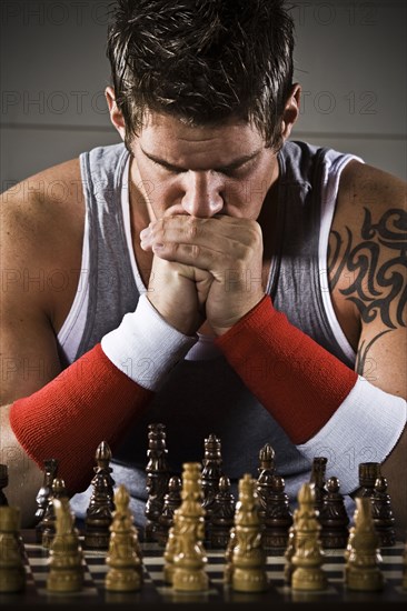 Body builder playing chess