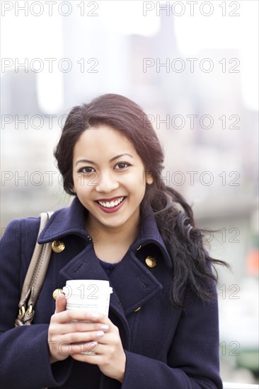 Mixed race woman drinking coffee