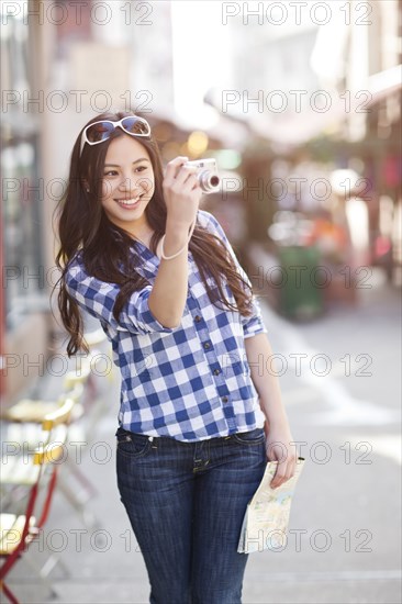 Chinese woman taking pictures with digital camera