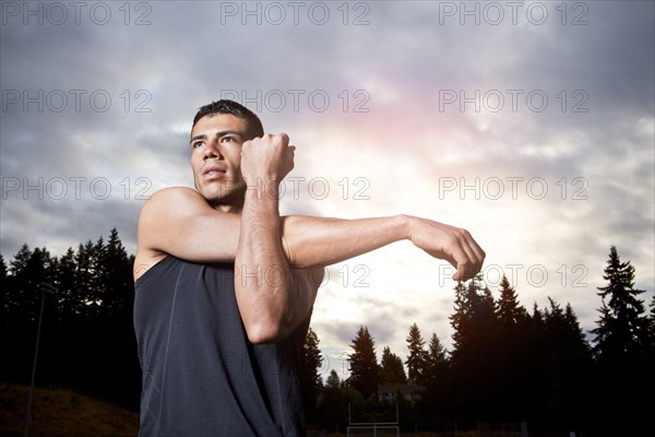 Hispanic man stretching before exercise