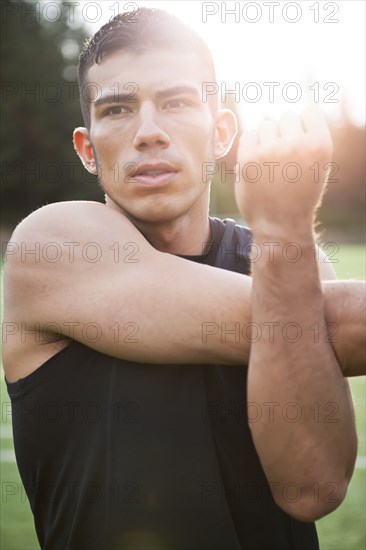 Hispanic man stretching before exercise