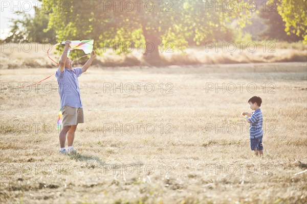 Chinese grandfather and grandson flying kite