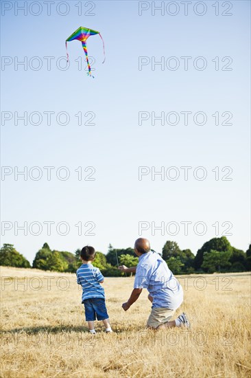 Chinese grandfather and grandson flying kite