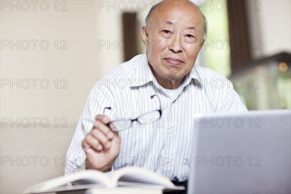 Chinese man with book and laptop