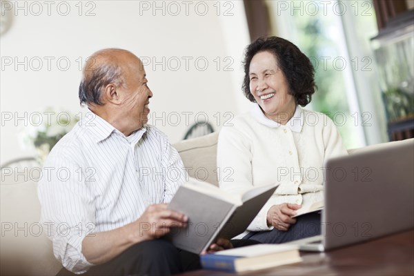 Chinese couple with book and laptop