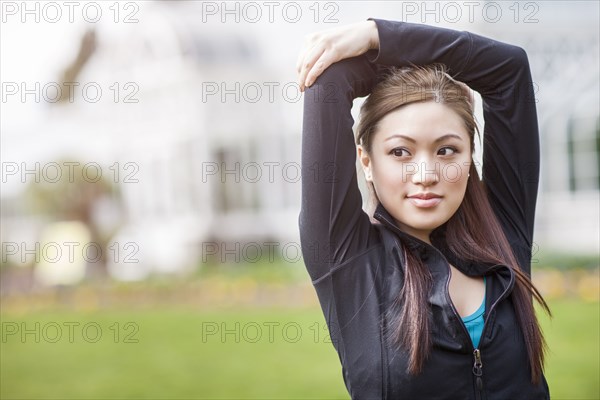 Asian woman with arms above her head
