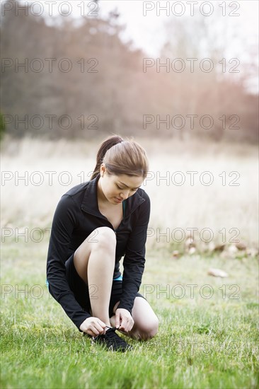 Asian woman tying her shoes