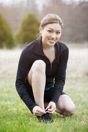 Asian woman tying her shoes