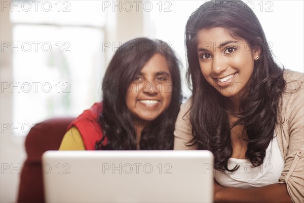 Indian mother and daughter using laptop together