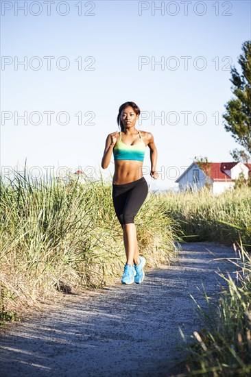 Mixed race woman running on dirt road