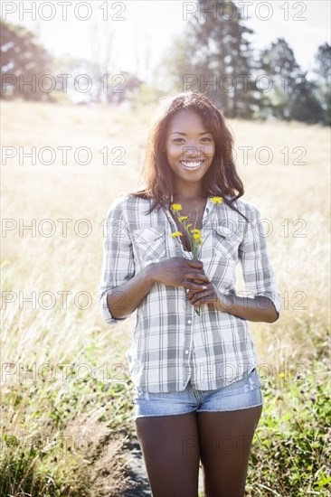 Mixed race woman standing in field