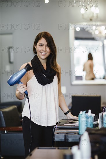 Stylist holding blow dryer in salon