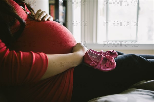 Asian woman holding her pregnant belly