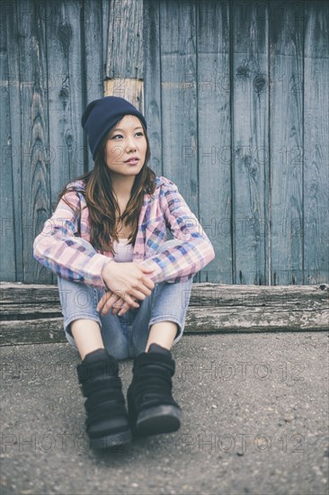 Korean woman sitting on city street