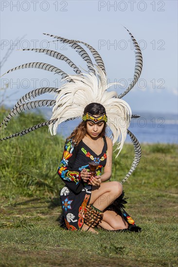 Native American woman in traditional headdress performing ceremony