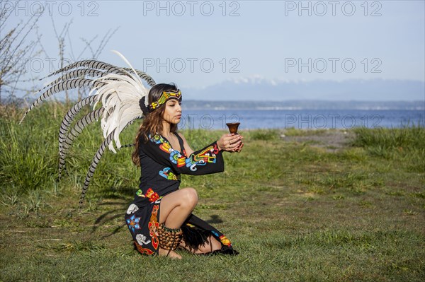 Native American woman in traditional headdress performing ceremony