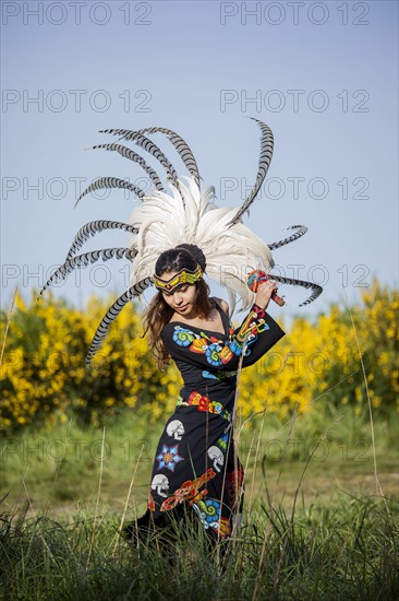 Native American woman in traditional headdress performing ceremony