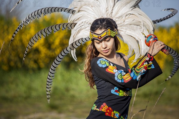 Native American woman in traditional headdress performing ceremony