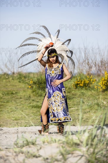 Native American woman in traditional headdress performing ceremony