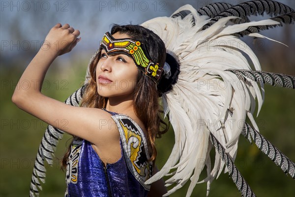 Native American woman in traditional headdress performing ceremony