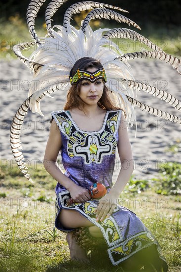 Native American woman in traditional headdress performing ceremony