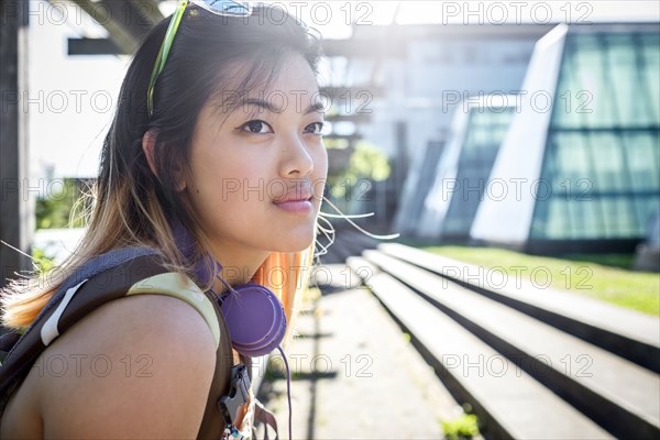 Portrait of pensive Chinese woman with headphones