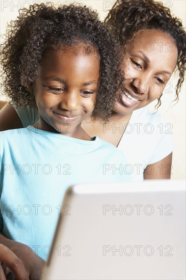 African mother and daughter using laptop