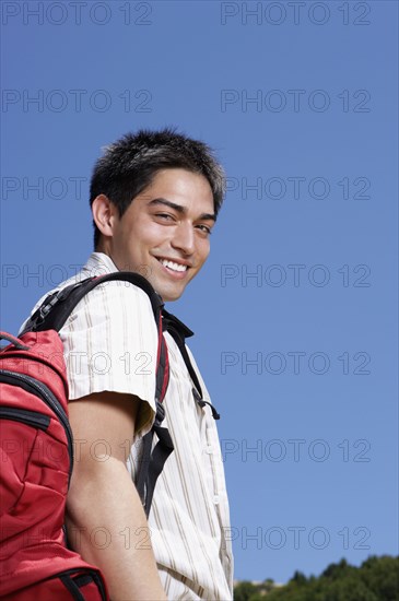 Hispanic man wearing backpack outdoors